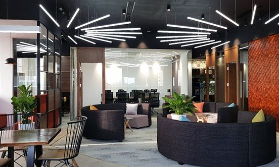 Circular couches populate a workspace with glass walls and lighting